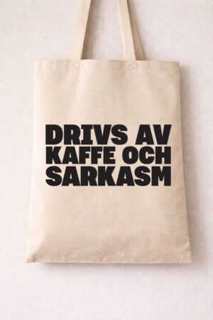 Drivs av kaffe och sarkasm tote bag